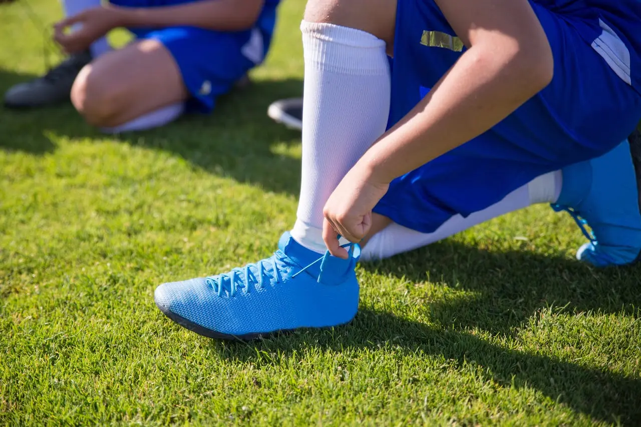 Youth player tyiing their cleats getting ready for upcoming game