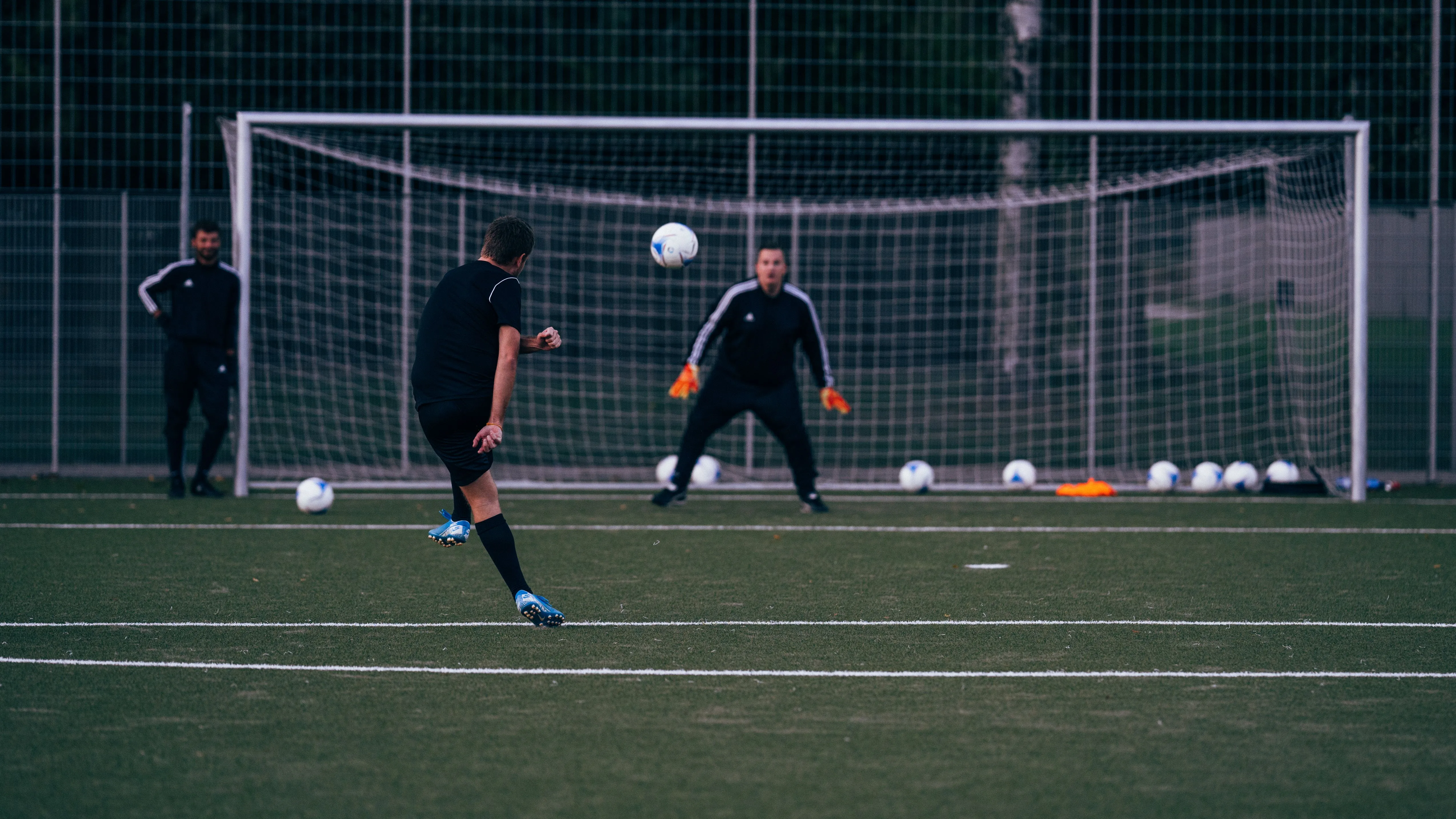 A soccer striker taking a shot in front of the goal in training