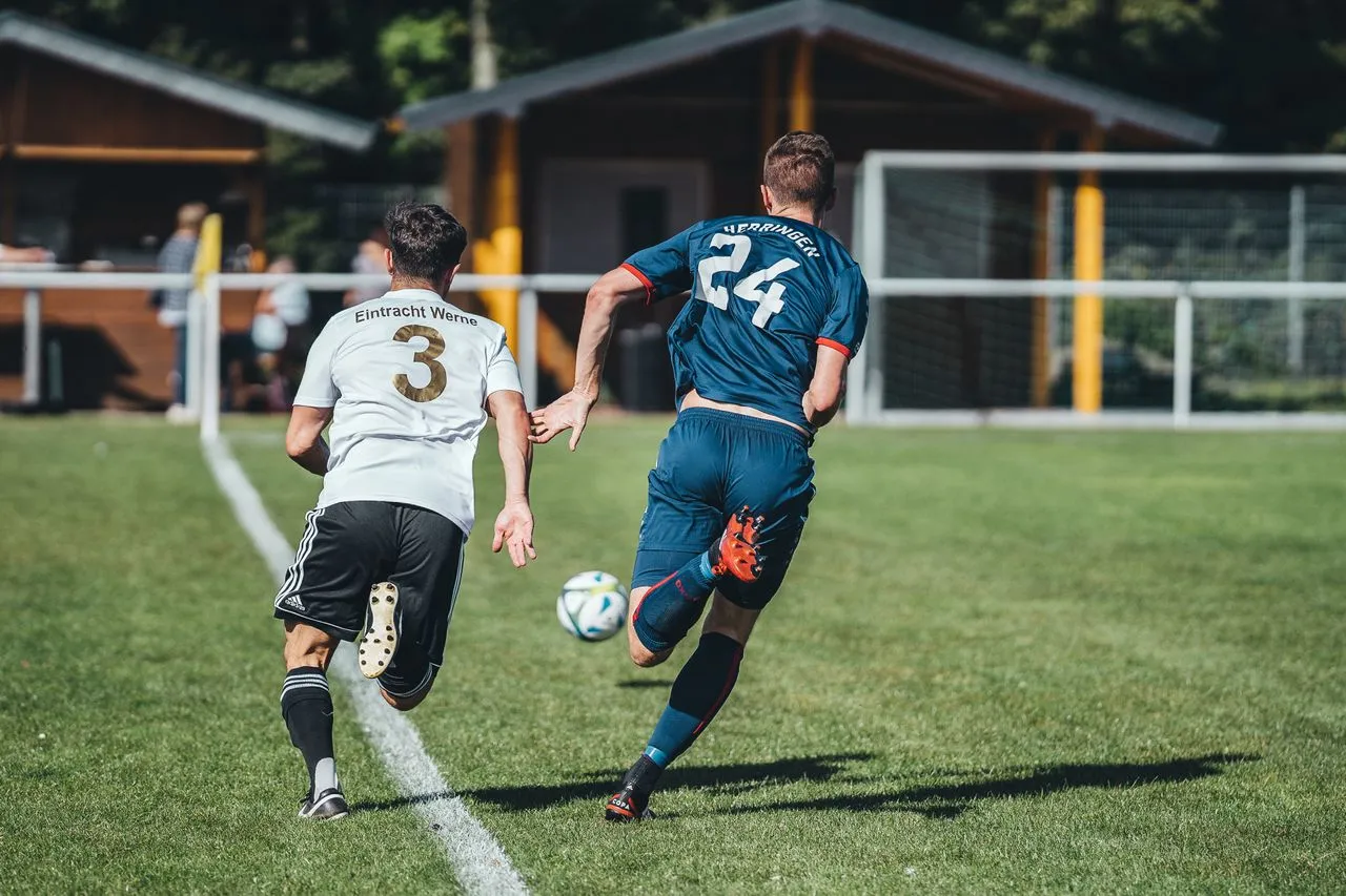 A young soccer winger driving at a defender near the touchline